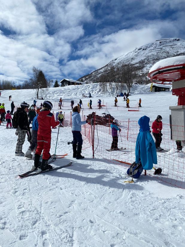 Personer med ski i kø