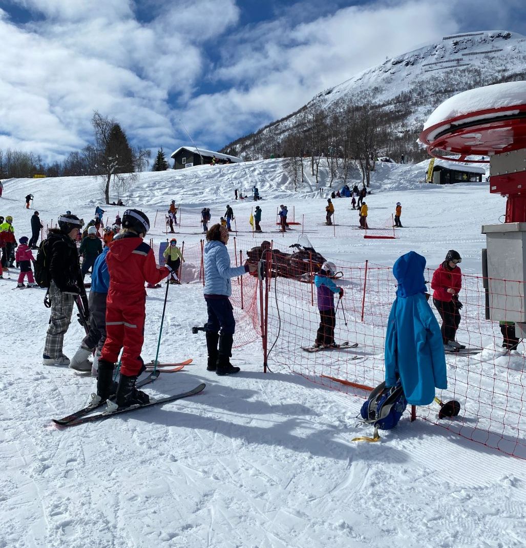Personer med ski i kø